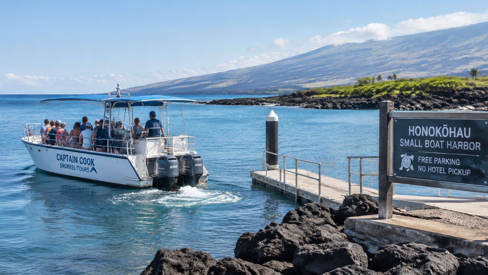 A Captain Cook snorkeling boat departs from the Honokohau Small Boat Harbor with tourists in Hawaii.
